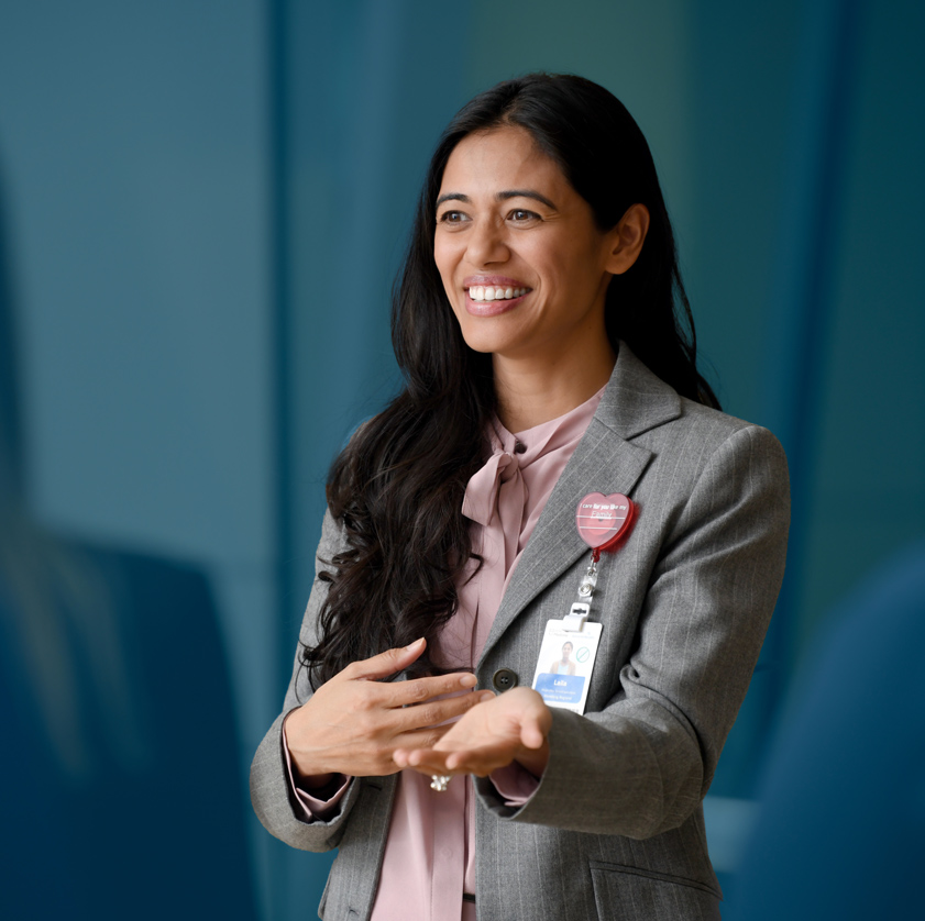 A smiling female business professional speaking in front of a group