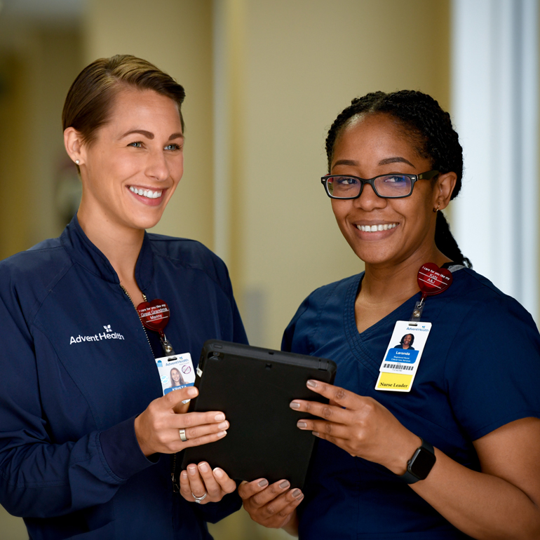 A smiling female nurse mentoring a smiling female nursing student