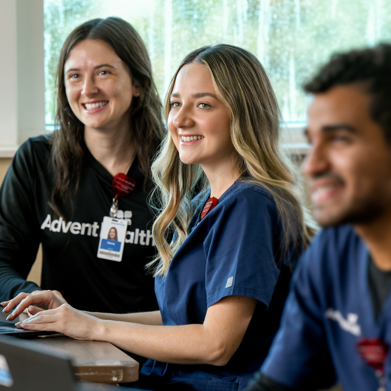 Three smiling nurse residents in a classroom setting