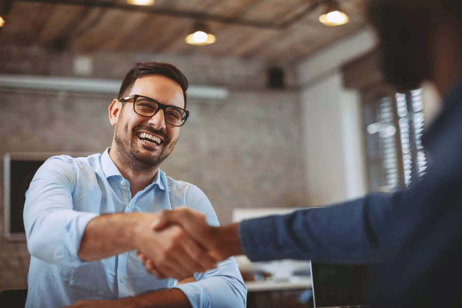 A man gives a handshake to the interviewer at a job interview
