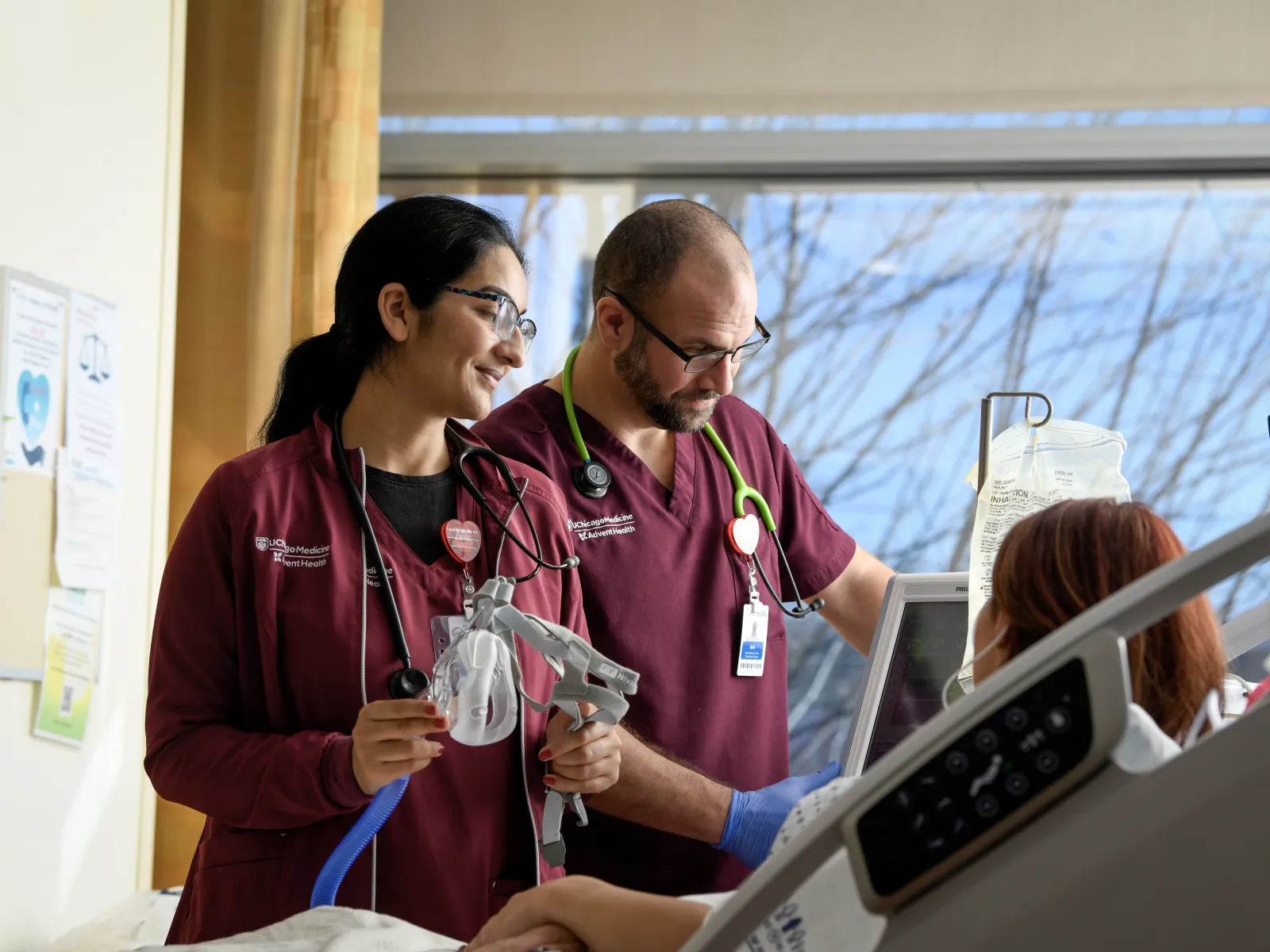 two uChicago Medicine AdventHealth Nurses caring for a patient