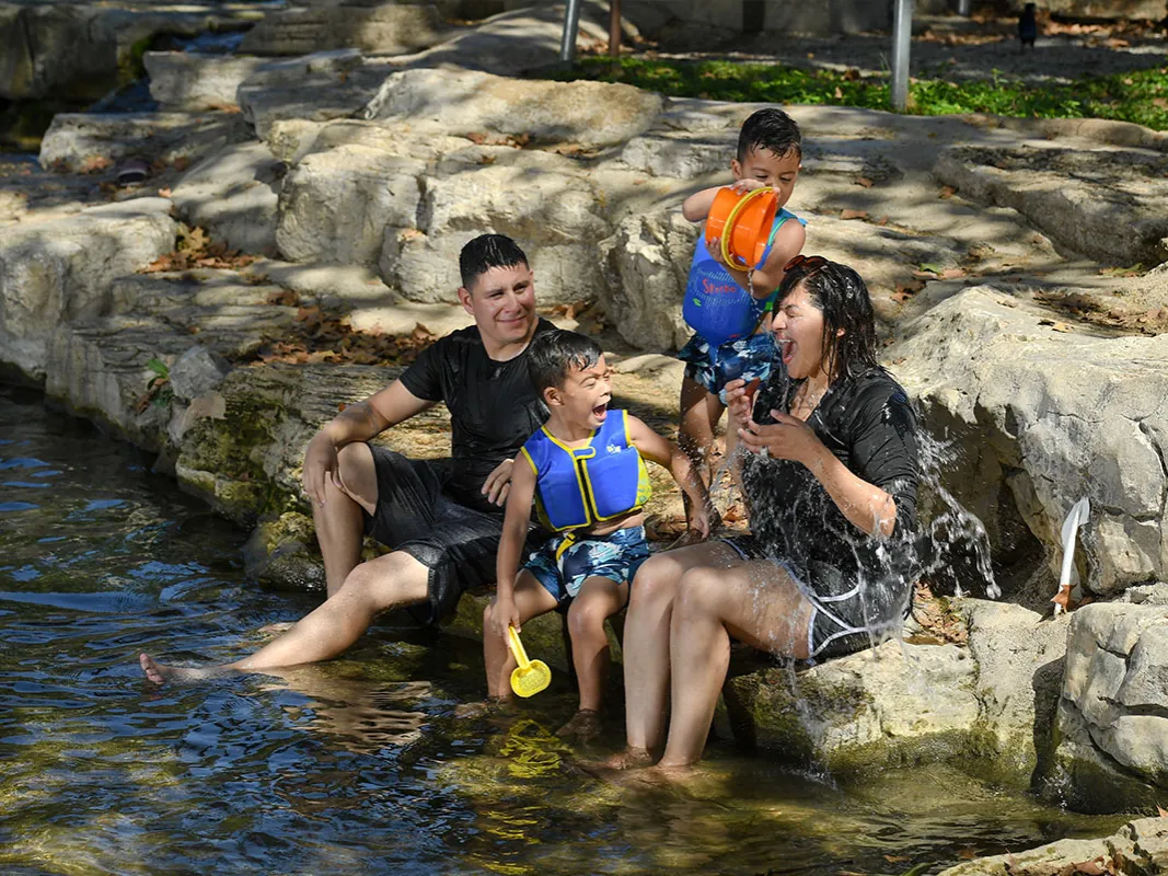 Family with children playing in a river