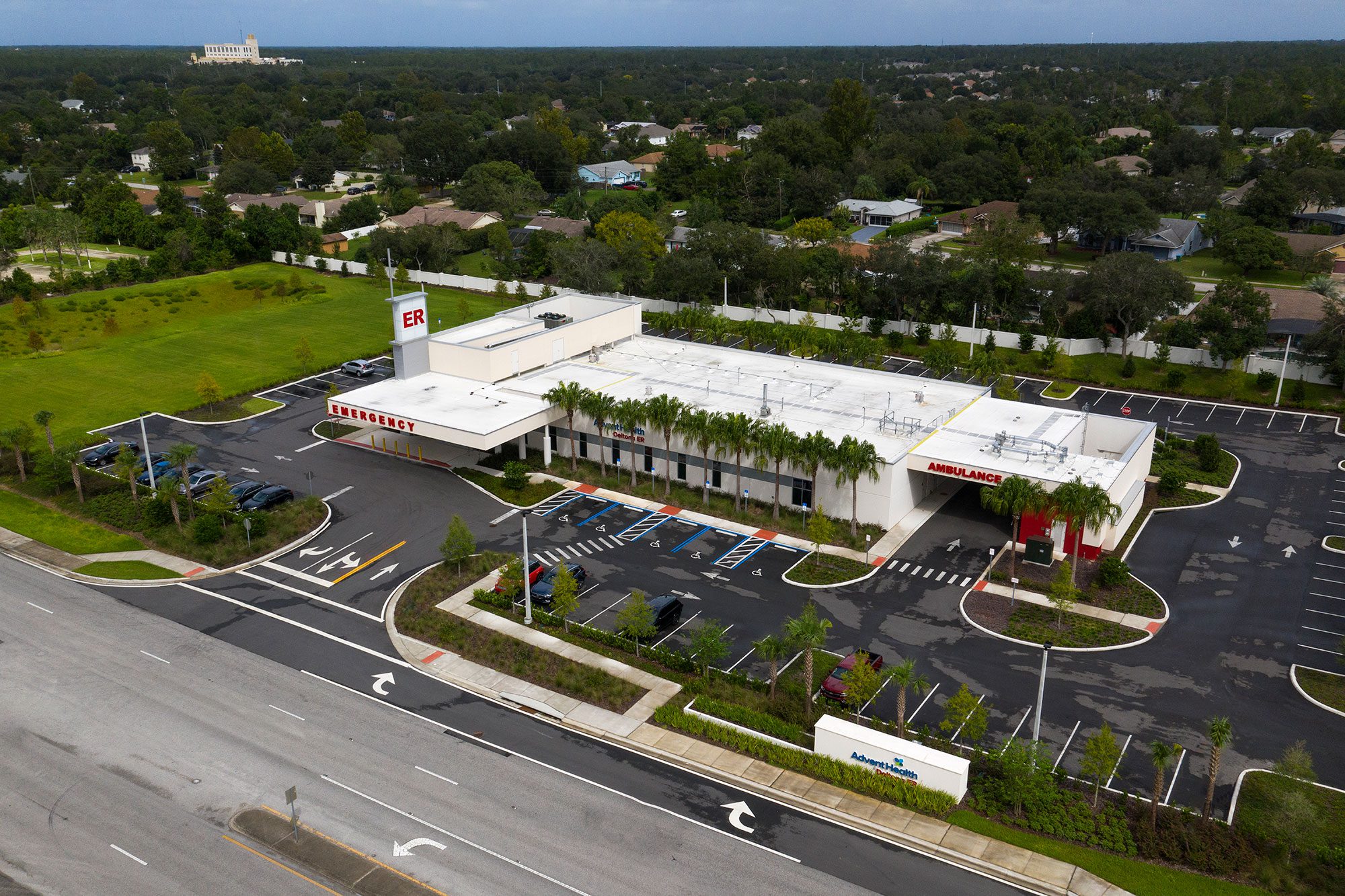 ah-deltona-er-area-2000×1333 Aerial view of the AdventHealth Deltona emergency department, showing the ER entrance, ambulance bay, parking areas, and surrounding neighborhood.