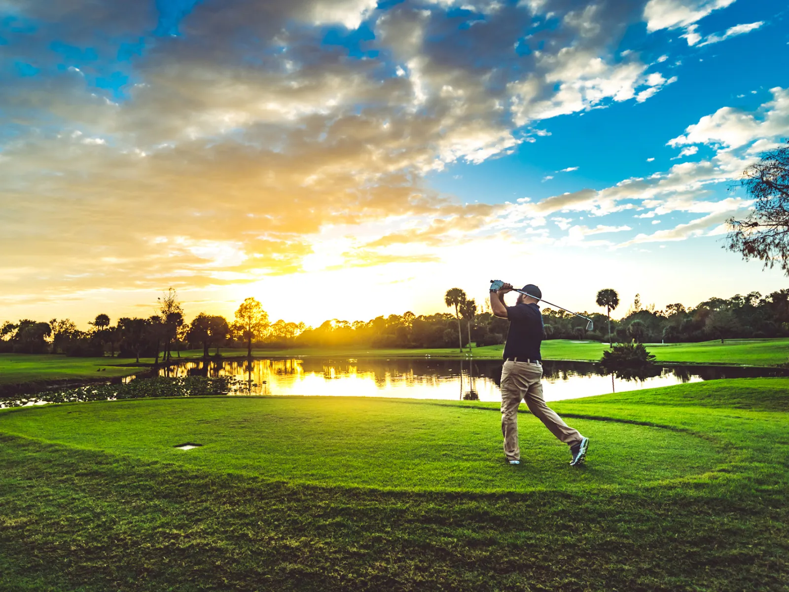 A Man Tees Off on a Florida Golf Course
